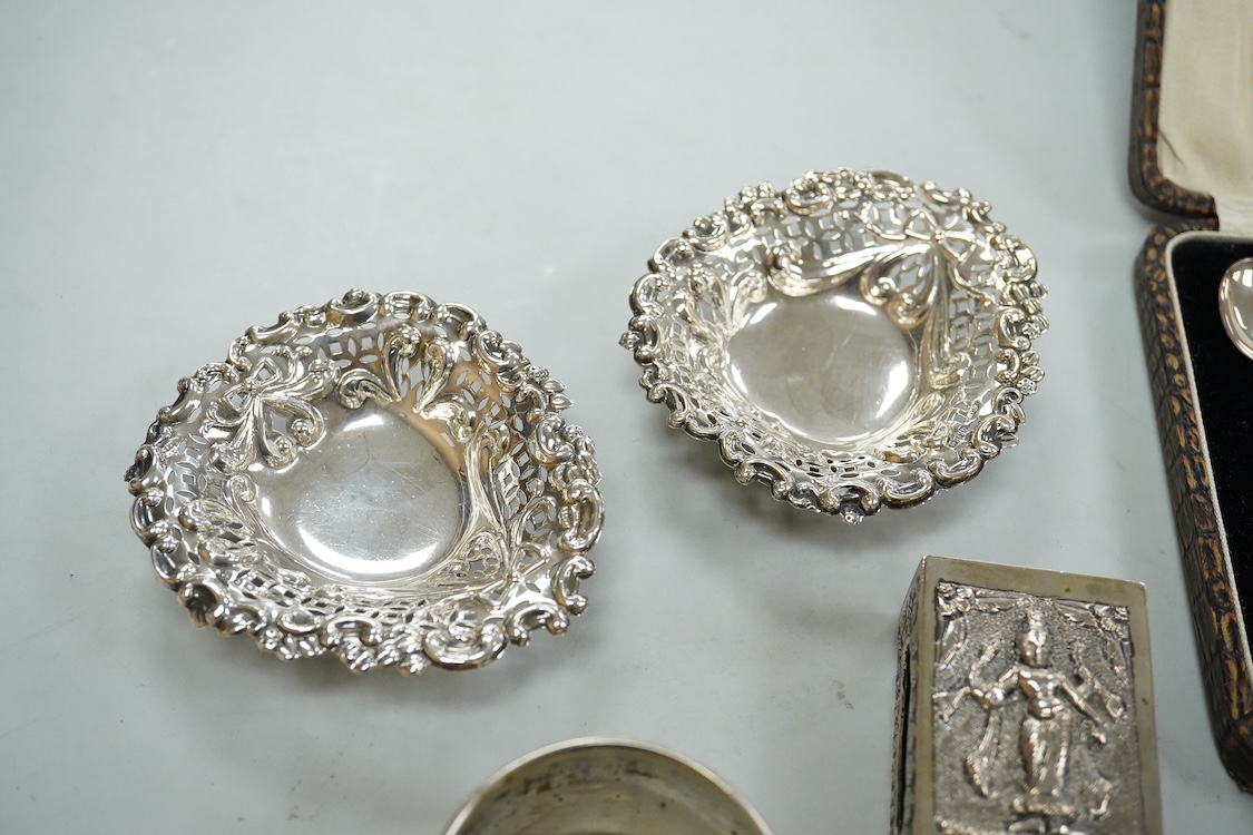 A collection silver and white metal to include a cased set of six George V seal top coffee spoons, Birmingham, 1927, a pair of Scottish napkin rings embossed with thistles, a pair of embossed heart shaped bonbon dishes,